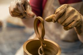 A male potter is making a vase. Pottery. Clay modeling. Making ceramics. A male potter is making a vase. Pottery. Clay modeling. High quality photo. Making ceramics with your own hands. A man in a workshop where ceramics are made.